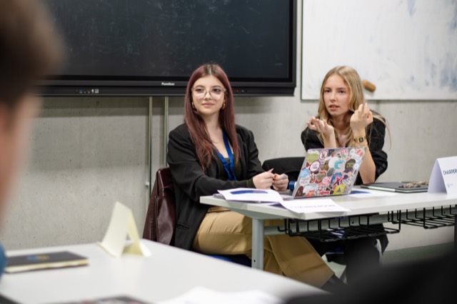 Two chairpersons address their committee, one gesturing while explaining procedure.